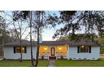 Newly renovated ranch home with white brick exterior, covered porch, and landscaping at 488 Society Rd, McClellanville, SC 29458