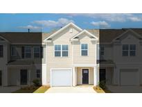 Two-story townhome with beige siding, white garage door, and dark-colored front door at 526 Golden Embers Way, Summerville, SC 29486