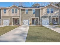 Two-story townhouses with attached garages, landscaping, and paved driveways at 8410 Hidden Bakers Trce, North Charleston, SC 29418