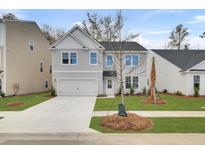 Two-story gray house with white accents, two-car garage, and well-manicured lawn at 1047 Old Cypress, Hanahan, SC 29410