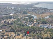 Aerial view of home nestled in a quiet neighborhood near water at 1081 Saint Thomas Island Dr, Charleston, SC 29492