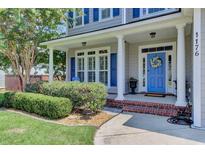 Two-story home with gray siding, blue shutters, and a welcoming front porch at 1176 Rivers Reach Dr, Wando, SC 29492