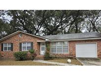 Brick ranch house with attached garage and mature trees at 1324 Ashley Hall Rd, Charleston, SC 29407