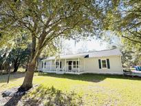 Ranch style home with a spacious front porch and well-maintained lawn at 1966 Suzanne St, Johns Island, SC 29455