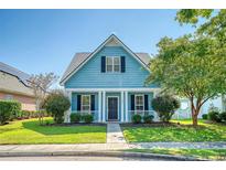 Charming light blue house with a front porch, landscaping, and walkway at 307 Pimpernel St, Summerville, SC 29483
