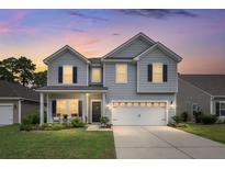 Two-story house with gray siding, white garage door, and landscaping at 3438 Great Egret Dr, Johns Island, SC 29455