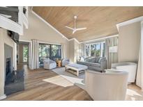 Spacious living room features hardwood floors, vaulted ceiling, fireplace, and access to deck at 604 Magnolia Walk, Edisto Island, SC 29438