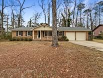 Brick ranch house with attached two-car garage and mature trees at 105 Gambels Ln, Summerville, SC 29485