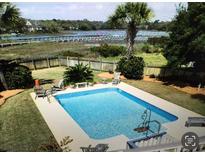 Inviting backyard pool with spacious deck, offering scenic waterway views at 1349 Seabass Cv, Charleston, SC 29412