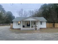 Charming white house with a front porch and fenced yard at 1420 Old Whitesville Rd, Moncks Corner, SC 29461
