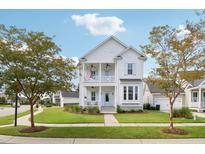 Two-story white house with light blue accents, a front porch, and a landscaped lawn at 1617 Bowsprit Ct, Mount Pleasant, SC 29466