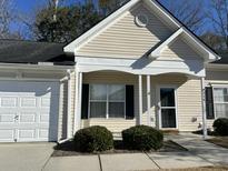 Tan house with white trim, a white garage door, and well-maintained landscaping at 214 Hardee Ave Ave, Summerville, SC 29485