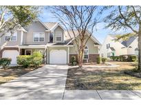 Two-story townhome with brick and siding exterior, attached garage, and landscaped yard at 8646 Grassy Oak Trl, North Charleston, SC 29420