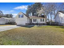 Beige house with a garage and patio, well-maintained lawn at 9609 Crosscut Dr, Ladson, SC 29456
