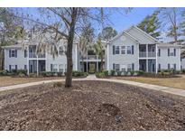 Two-story apartment building with gray siding, balconies, and landscaping at 1105 Grove Park Dr, Charleston, SC 29414