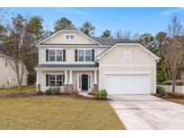 Two-story house with beige siding, a white garage door, and landscaping at 126 Veranda Dr, Summerville, SC 29485