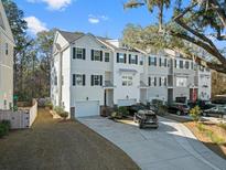 Three-story townhouses with attached garages and landscaping at 137 Claret Cup Way, Charleston, SC 29414