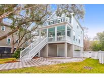 Two-story light blue house with white trim, a front porch, and a landscaped yard at 1442 Eutaw Battalion Dr, Charleston, SC 29412