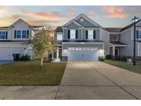 Two-story house with gray siding, white garage door, and landscaped lawn at 241 Swamp Creek Ln, Moncks Corner, SC 29461