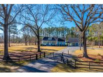 A charming house with a large front yard and gated entrance at 490 Cummings Chapel Rd, Ridgeville, SC 29472