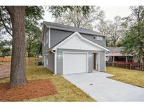 Gray two-story house with white garage door and landscaping at 5635 Dobson St, North Charleston, SC 29406