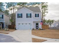 Two-story house with attached garage, landscaping, and American flag at 668 Silver Spruce St, Summerville, SC 29486