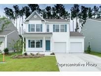 Two-story house with white siding, teal door, and two-car garage at 1015 Marsh Harrier Dr # Cc3-3-2, Ravenel, SC 29470