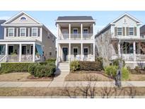 Two-story tan house with white columns, porch, and landscaping at 1040 Hills Plantation Dr, Charleston, SC 29412