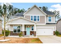 Two-story house with light gray siding, stone accents, and a two-car garage at 339 Spectrum Rd, Summerville, SC 29486