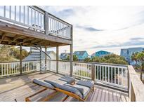 Relaxing deck with wooden chairs, offering scenic neighborhood views at 904 E Arctic Ave, Folly Beach, SC 29439