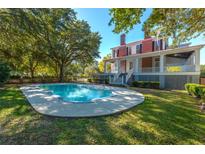 Inviting kidney-shaped pool surrounded by lush landscaping at 927 Fishburne Rd, Pinopolis, SC 29469