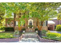 Brick home with lush landscaping, black metal fence, and a charming front entrance at 149 S Battery St, Charleston, SC 29401