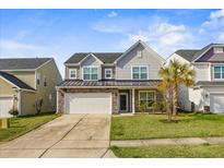 Two-story house with gray siding, stone accents, and a two-car garage at 187 Weeping Cypress Dr, Moncks Corner, SC 29461