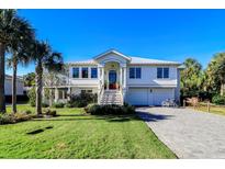 Two-story home with white siding, metal roof, and a brick driveway at 3 43Rd Ave, Isle of Palms, SC 29451