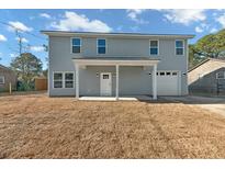 Two-story house with gray siding, a covered porch, and a two-car garage at 5889 N Rhett Ave, Hanahan, SC 29410
