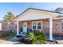 Brick ranch house with a light blue front door and landscaping at 9772 Berrywood Dr, Ladson, SC 29456