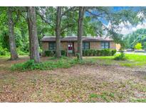 Brick ranch house with mature trees and a large front yard at 1088 Quiet Rd, Mount Pleasant, SC 29464