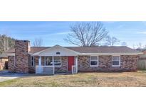 Brick ranch house with red front door, white trim, and a landscaped yard at 136 Jean Wells Dr, Goose Creek, SC 29445
