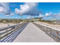Wooden pier leading to the ocean with views of ocean and beachfront property at 1400 Ocean Blvd # 104-A, Isle of Palms, SC 29451