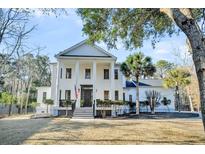 White two-story home with columns, a porch, and a well-manicured lawn at 1779 Greenspoint Ct, Mount Pleasant, SC 29466