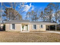 Brick ranch house with carport, landscaping, and a green door at 7640 Hillview Ln, North Charleston, SC 29420