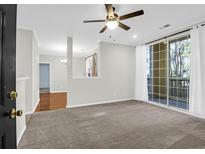 Bright living room with carpet, ceiling fan, and sliding glass doors leading to a balcony at 1600 Long Grove Dr # 1712, Mount Pleasant, SC 29464