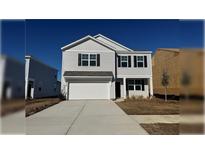 Two-story house with gray siding, white garage door, and landscaping at 185 Carolina Groves Blvd, Moncks Corner, SC 29461