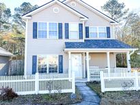 Two-story house with tan siding, white fence, and a covered porch at 207 Moon Dance Ln, Summerville, SC 29483