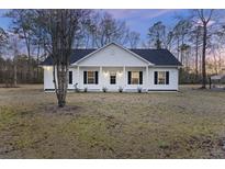 Charming one-story house with white siding, black shutters, and a covered porch at 326 Turner Ln, Round O, SC 29474
