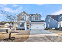 Two-story gray house with white garage door and landscaping at 435 Nelliefield Trl, Wando, SC 29492