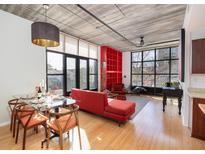 Bright living room with hardwood floors, red sofa, and large windows at 1 Cool Blow St # 126, Charleston, SC 29403