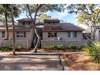 Two-story townhome with gray siding, fenced yard, and mature trees at 1240 Creek Watch Trce, Seabrook Island, SC 29455