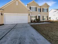 Two-story house with beige siding, white garage door, and landscaped yard at 158 Mayfield Dr, Goose Creek, SC 29445