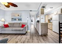 Bright living room with grey sofa and hardwood floors at 219 Sea Cloud Cir, Edisto Island, SC 29438